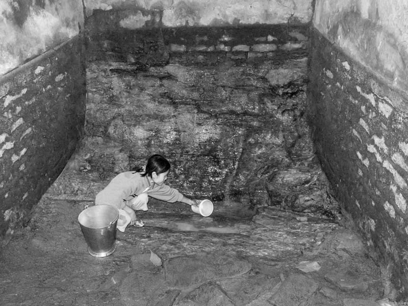 Human Right to Water in Nagaland - 'Scooping' water out of a nearly dried protected spring-fed tank in Mokokchung town